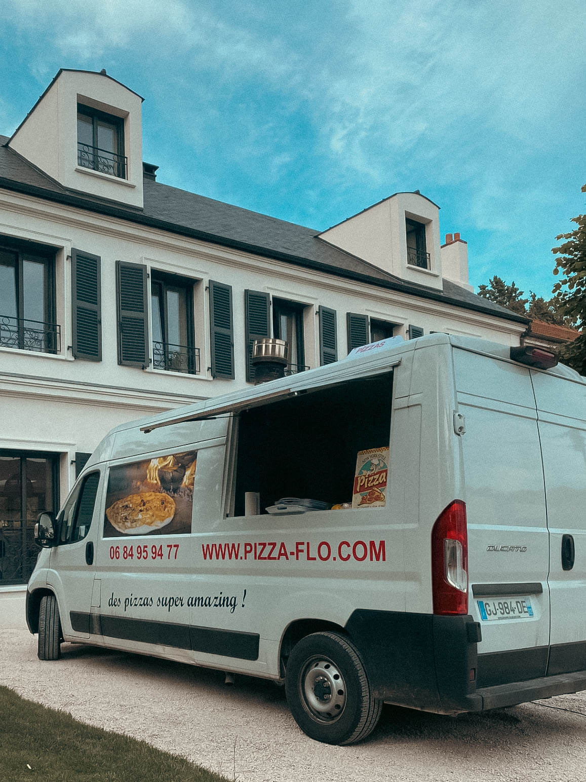 Photo d'un food truck de pizzas en prestation devant une maison privée