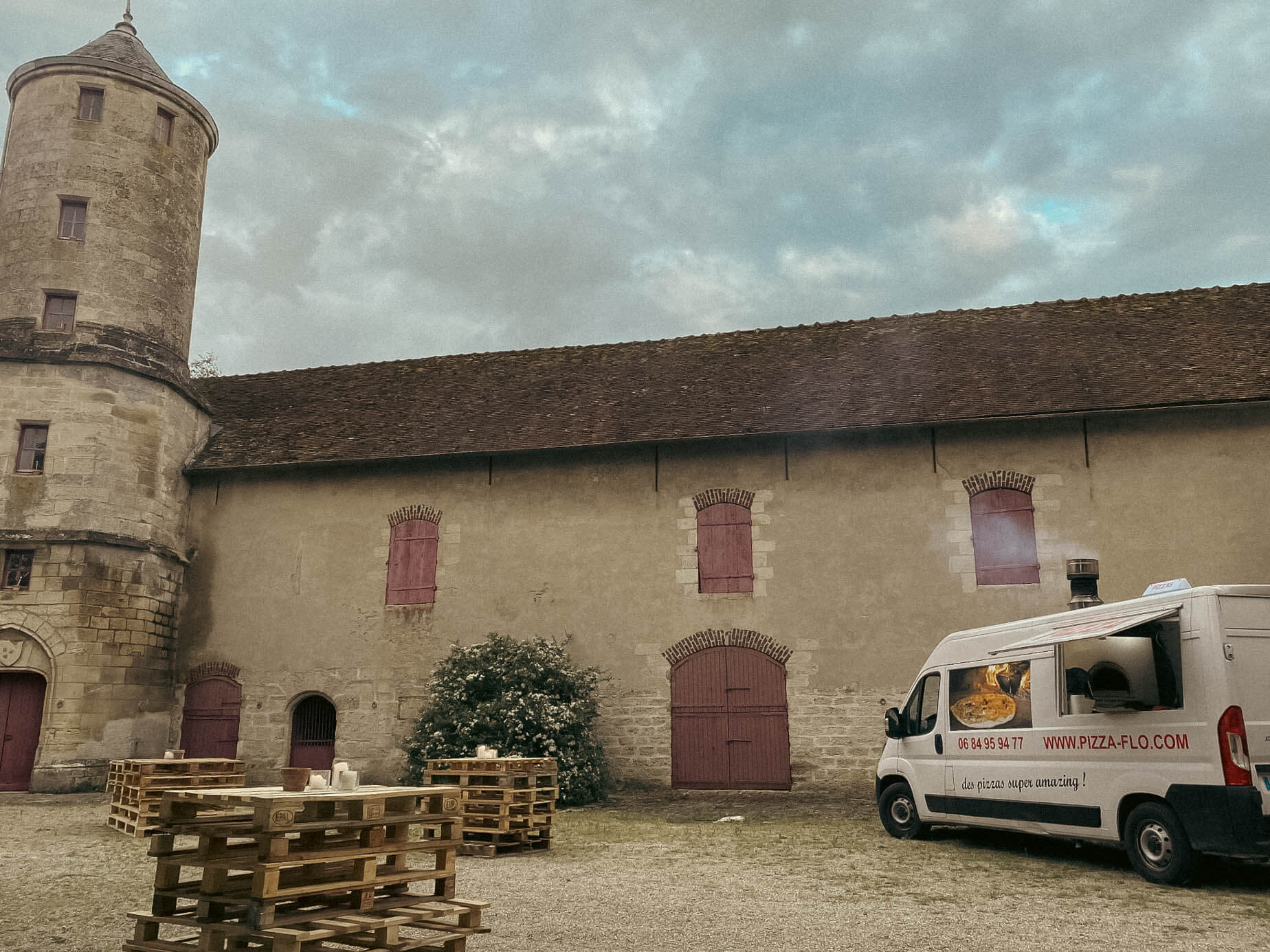 Photo d'un food truck de pizzas en prestation devant un chateau médévial