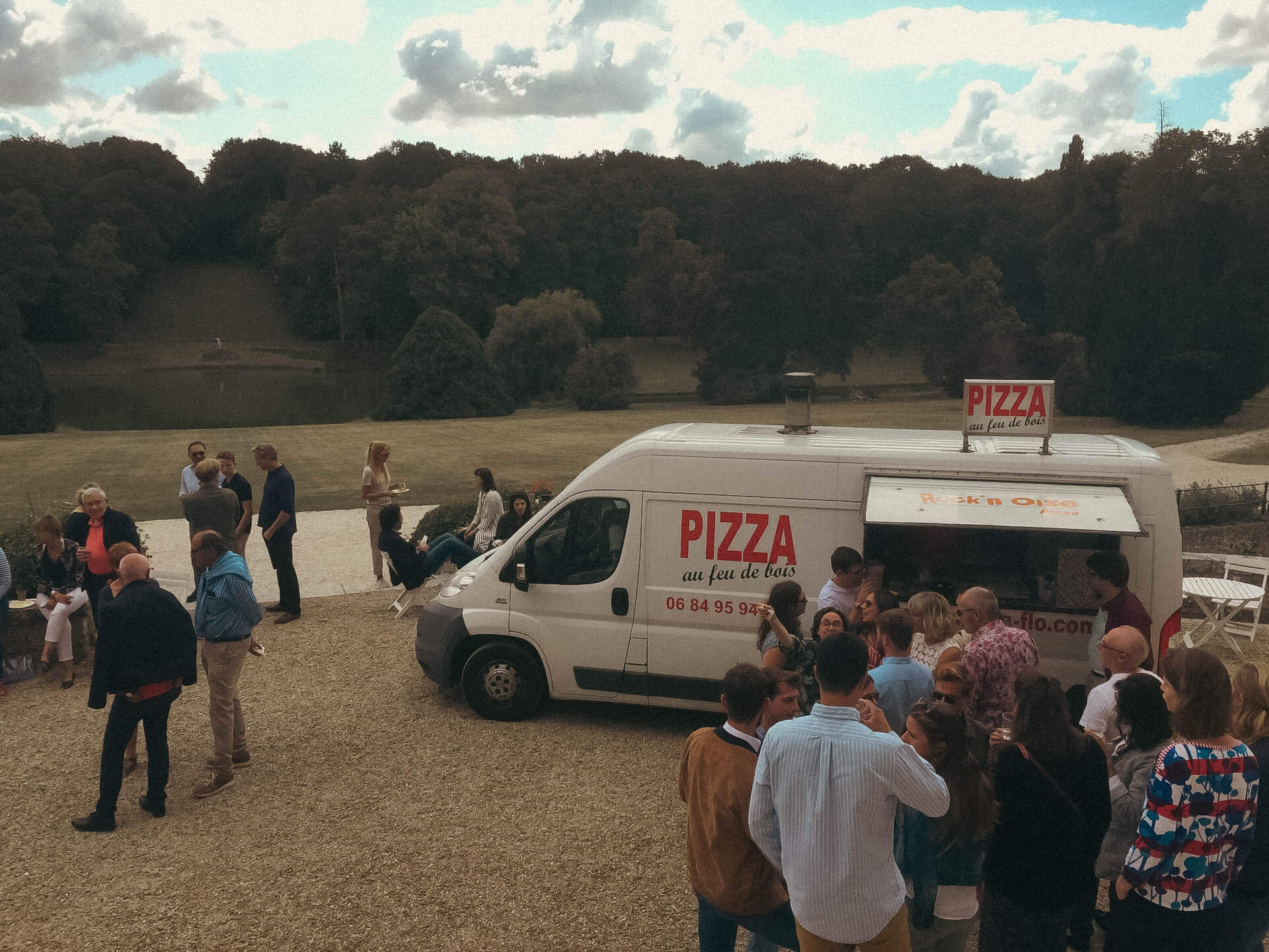 Photo d'un food truck de pizzas en prestation dans un jardin de chateau